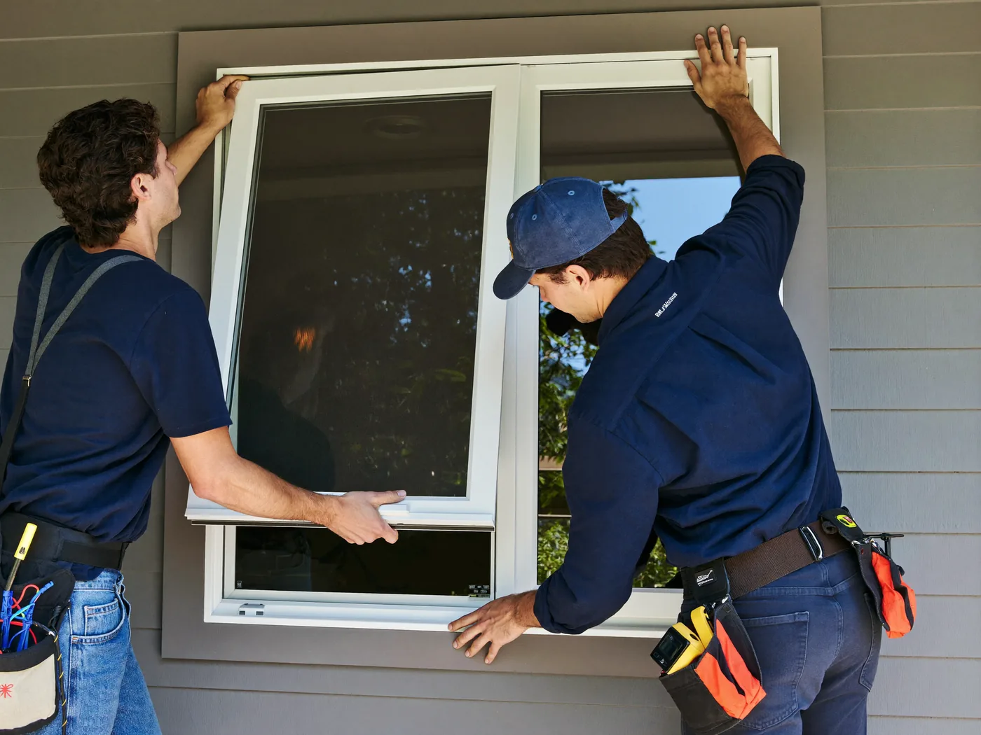 Two West Coast Windows installers fitting a new replacement window
